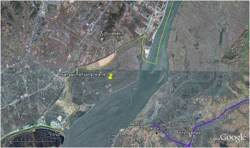 Figure 6. Hwanggumpyong Island with the international border between the DPRK and China shown in yellow. The island is nestled against the Chinese industrial zone of Donggang. (Photo:Google Earth and GeoEye)
