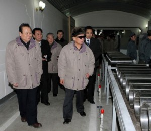 Kim Jong Il inspecting aluminum tubes.