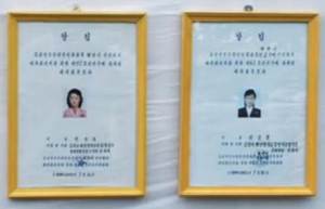 Certified notices of the deputy candidates of Pyongyang City People’s Assembly (on the left) and Songyo District People’s Assembly (on the right) registered in the electoral district No. 117, sub-constituency No. 62, located at the Kim Jong Suk Textile Mill in Songyo district, Pyongyang. Photo: KCTV. 