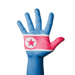 Open hand raised, North Korea flag painted
