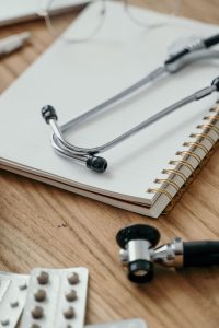 medical equipment sitting on a notepad upon a desk.